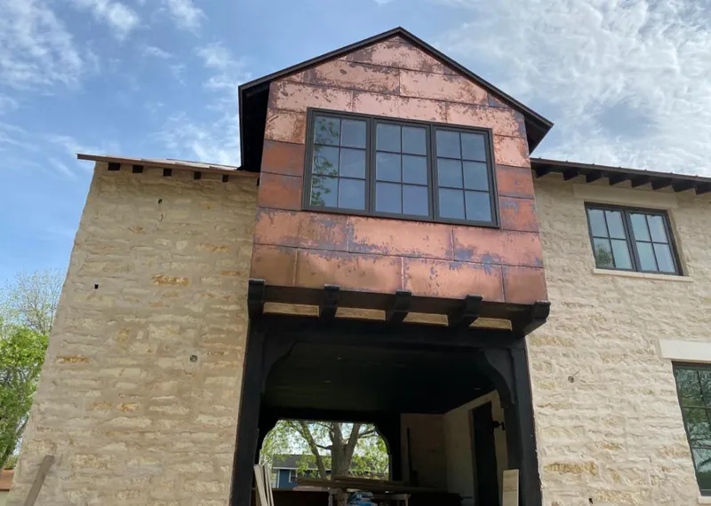Copper metal panel facade on a stone building for Skylight Installation in Rockwood